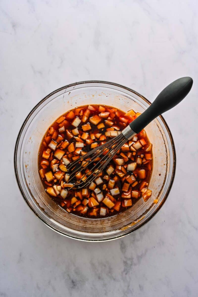 The sauce for honey sesame chicken whisked together in a glass bowl.