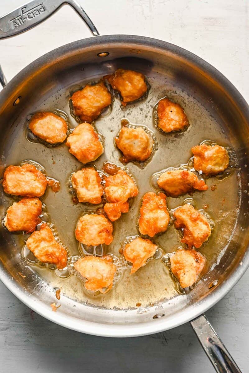 Cooked chicken pieces in a large skillet.