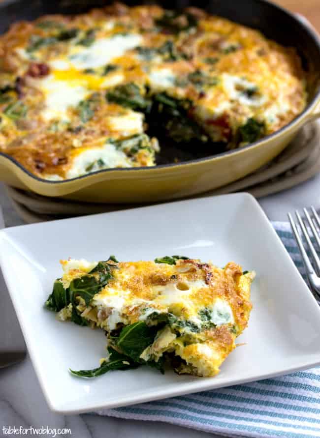 A slice of turkey and vegetable frittata on a square plate, next to a full frittata in a cast iron skillet.