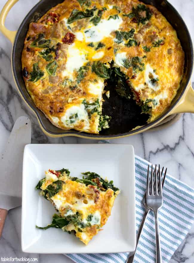 Overhead view of a slice of turkey and vegetable frittata on a square plate, next to a full frittata in a cast iron skillet.