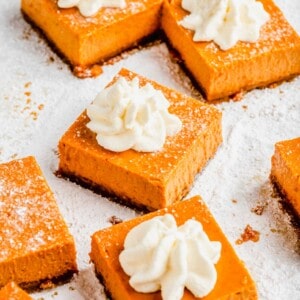 Close up of maple pumpkin cheesecake bars topped with whipped cream