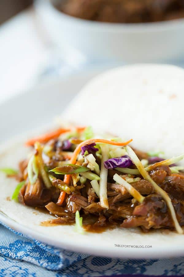 Slow cooker Korean tacos via tablefortwoblog.com. The tender & flavorful pork is wrapped inside a warm tortilla and topped with a tangy slaw!