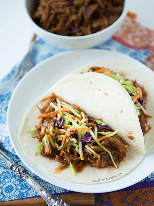 Slow cooker Korean tacos via tablefortwoblog.com. The tender & flavorful pork is wrapped inside a warm tortilla and topped with a tangy slaw!