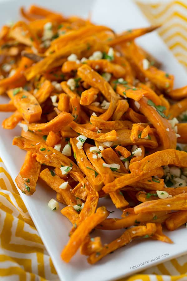 These baked garlic sweet potato fries are a great side dish for any burger or whenever the craving hits! Recipe on tablefortwoblog.com