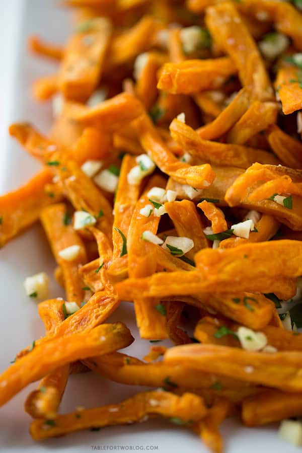 These baked garlic sweet potato fries are a great side dish for any burger or whenever the craving hits! Recipe on tablefortwoblog.com