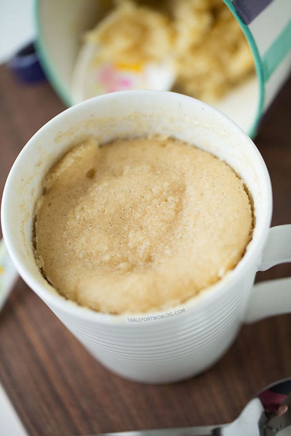 The moistest very vanilla mug cake is like a fluffy vanilla cupcake in a mug! Recipe on tablefortwoblog.com