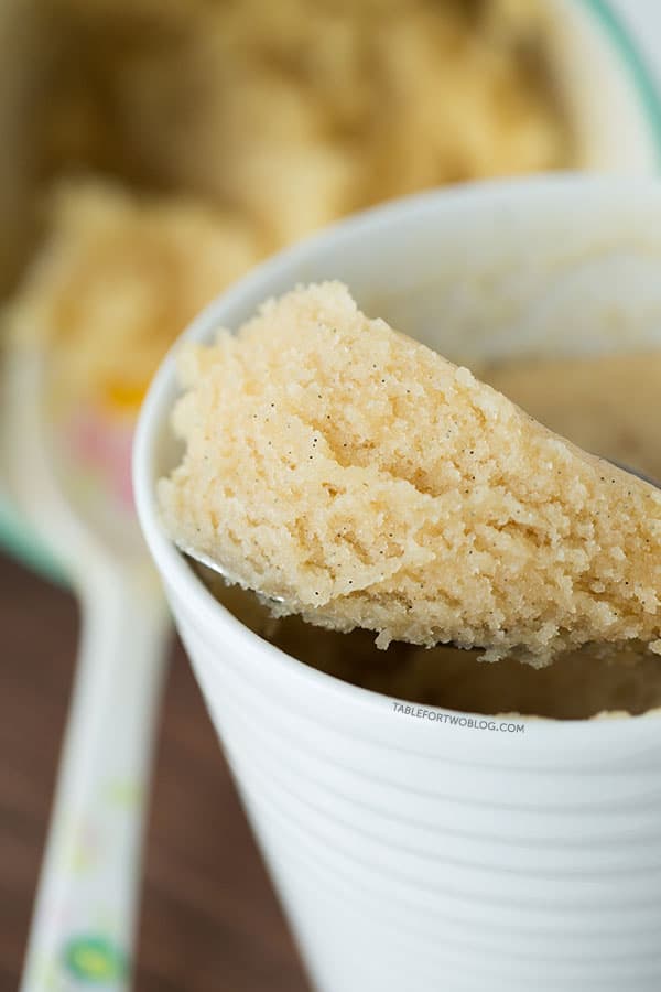 The moistest very vanilla mug cake is like a fluffy vanilla cupcake in a mug! Recipe on tablefortwoblog.com