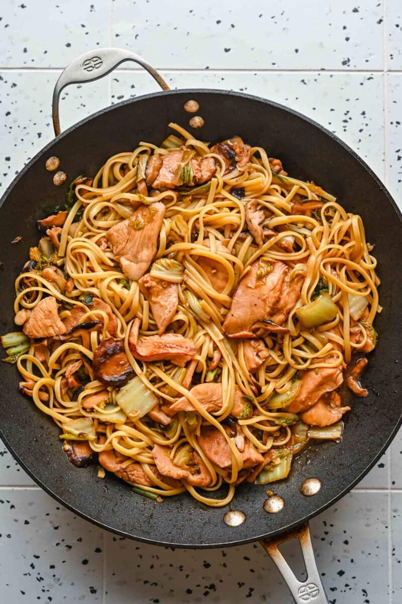 Finished chicken lo mein in a wok.