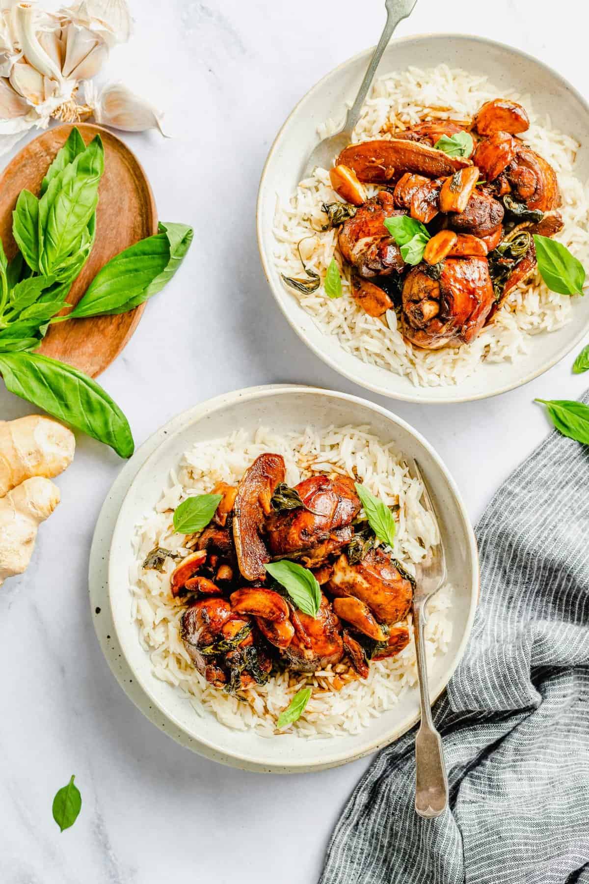 Overhead view of two bowls of three cup chicken and rice.