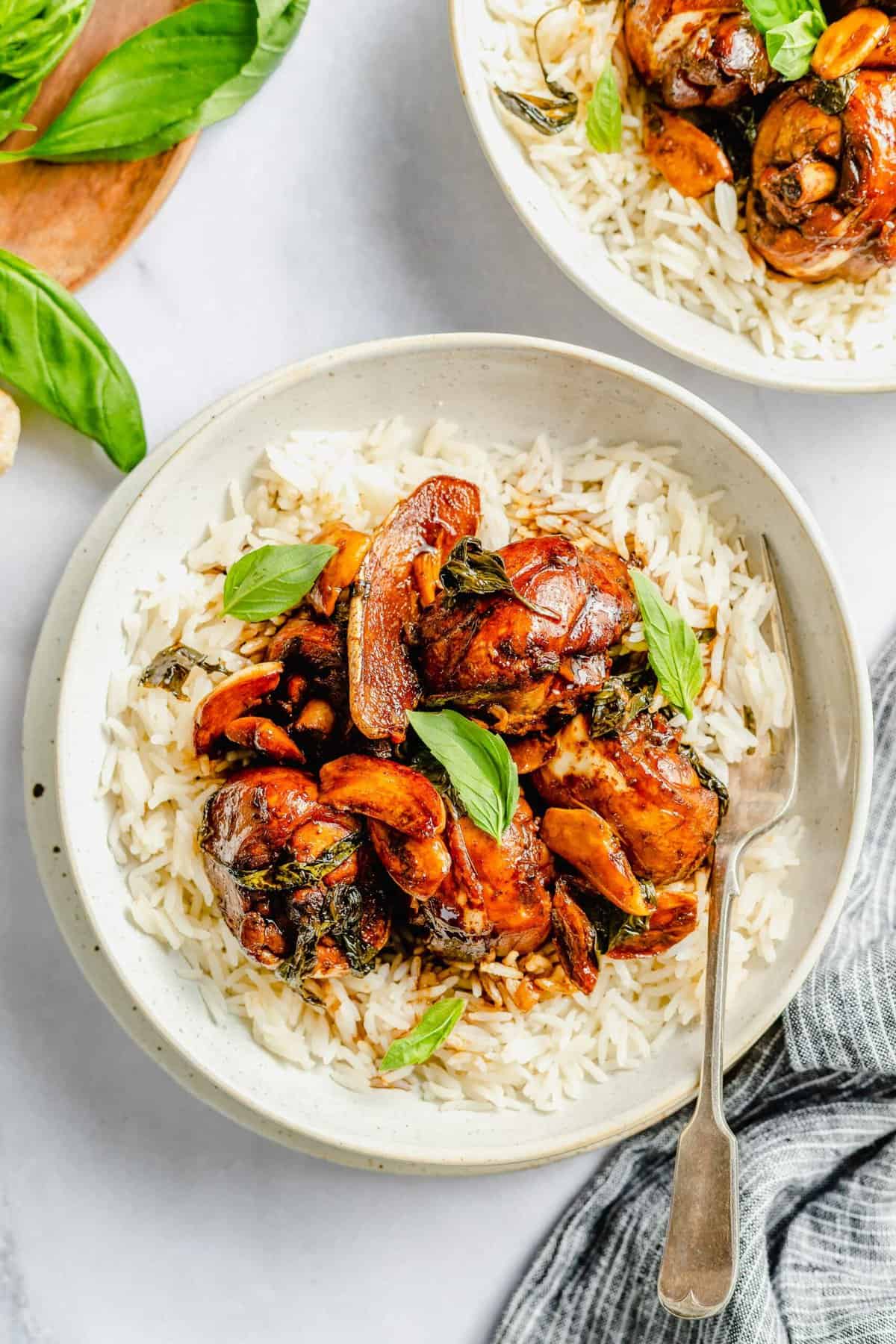 Overhead view of three cup chicken in bowl with rice.