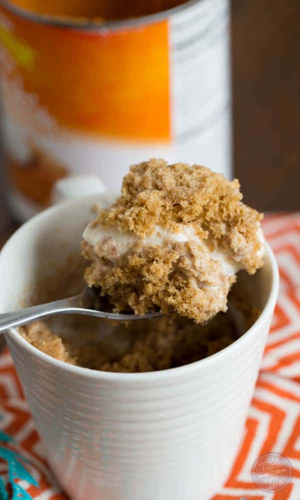 Pumpkin spice mug cake topped with creamy vanilla bean ice cream is Fall perfection...in a mug! Literally! Recipe on tablefortwoblog.com