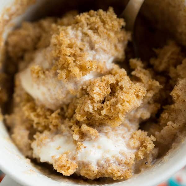Pumpkin spice mug cake topped with creamy vanilla bean ice cream is Fall perfection...in a mug! Literally! Recipe on tablefortwoblog.com