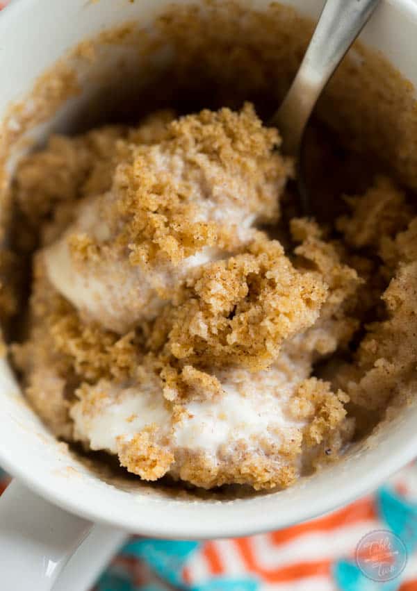 Pumpkin spice mug cake topped with creamy vanilla bean ice cream is Fall perfection...in a mug! Literally! Recipe on tablefortwoblog.com