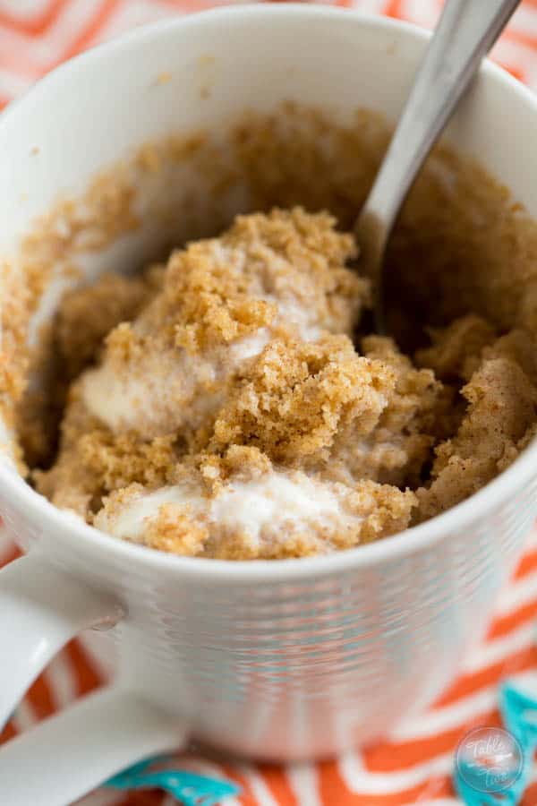 Pumpkin spice mug cake topped with creamy vanilla bean ice cream is Fall perfection...in a mug! Literally! Recipe on tablefortwoblog.com