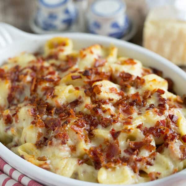 Mac and cheese casserole topped with crumbled bacon in a baking dish.