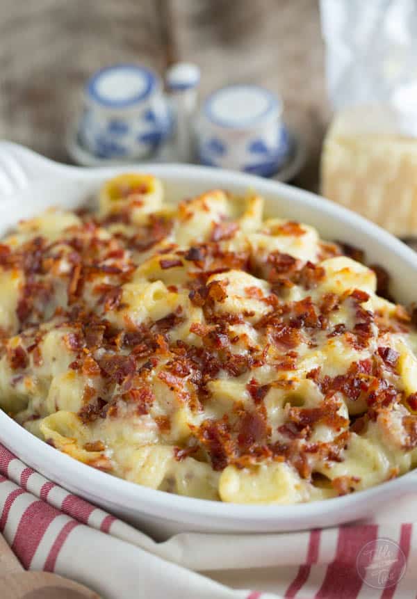 Mac and cheese casserole topped with crumbled bacon in a baking dish.
