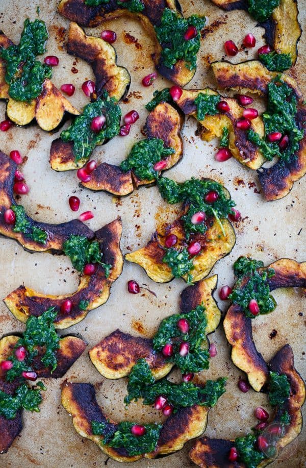 Roasted acorn squash with arugula pesto and pomegranate is a great side dish addition to any meal! You'll love how vibrant and colorful this side dish looks on your table!