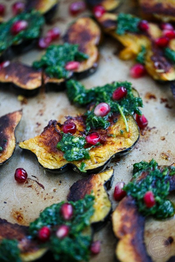 Roasted acorn squash with arugula pesto and pomegranate is a great side dish addition to any meal! You'll love how vibrant and colorful this side dish looks on your table!