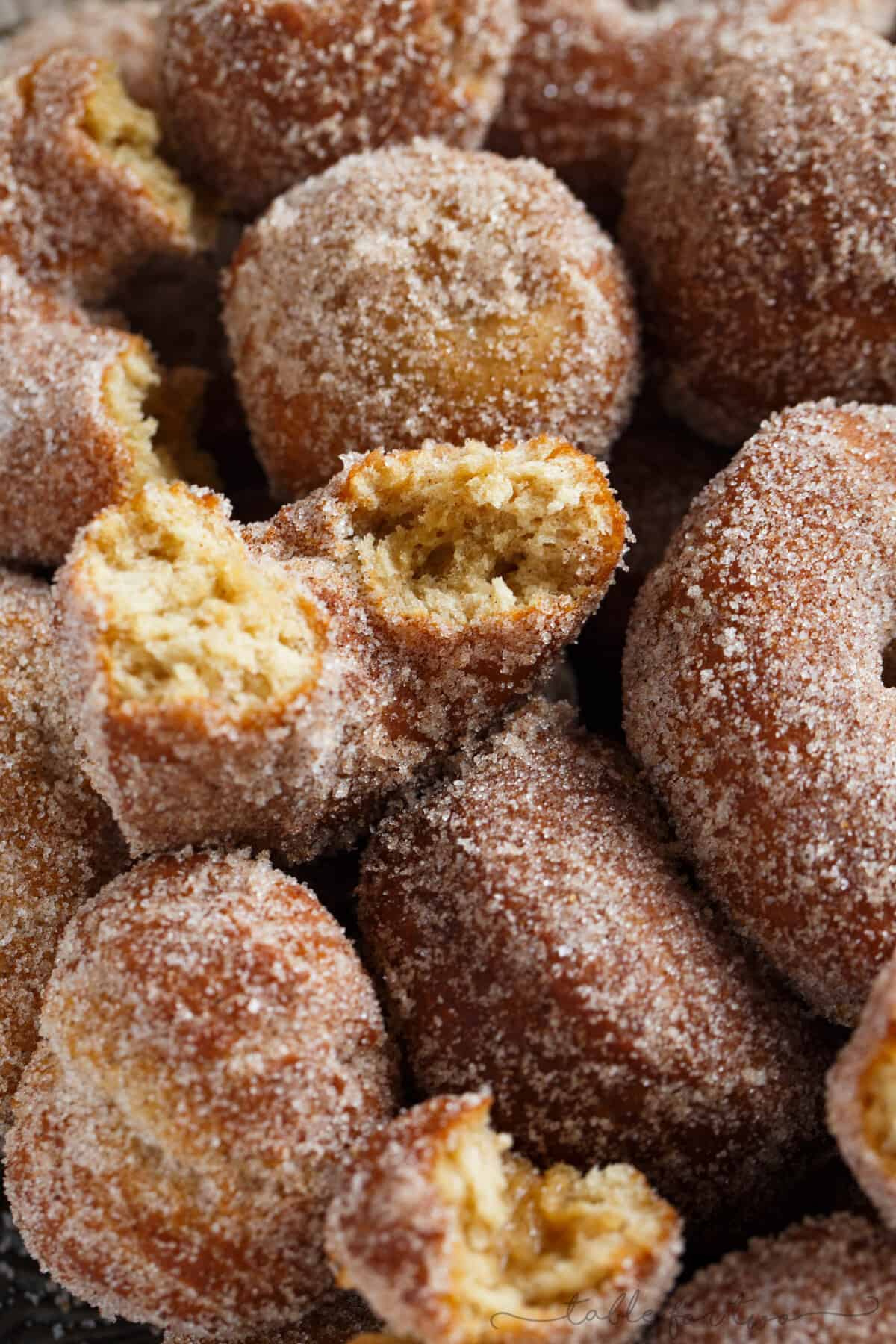 Close-up shot of apple cider doughnuts, with one torn in half