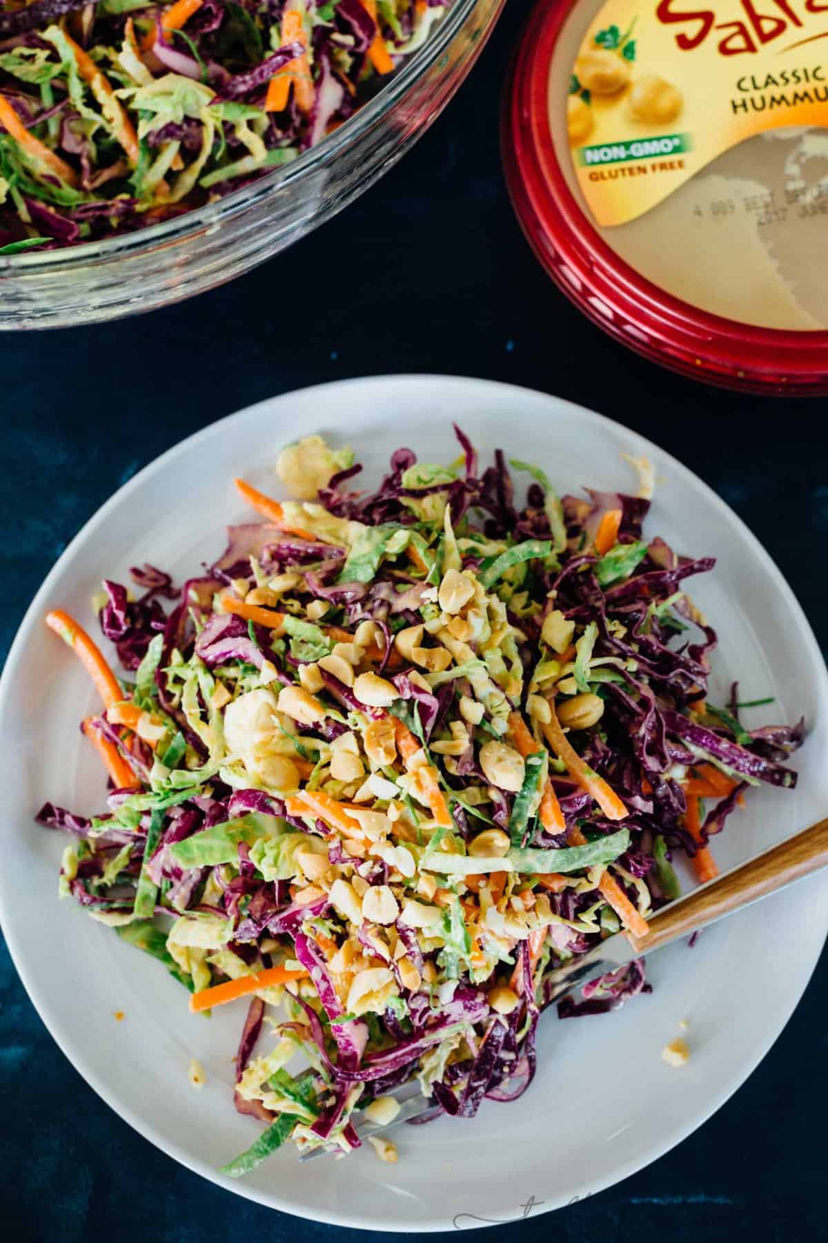 This cabbage slaw is a crisp and refreshing side dish for your next gathering! The creamy hummus dressing made with @sabradips classic hummus is going to be one of your new favorites to drizzle on everything! #ad