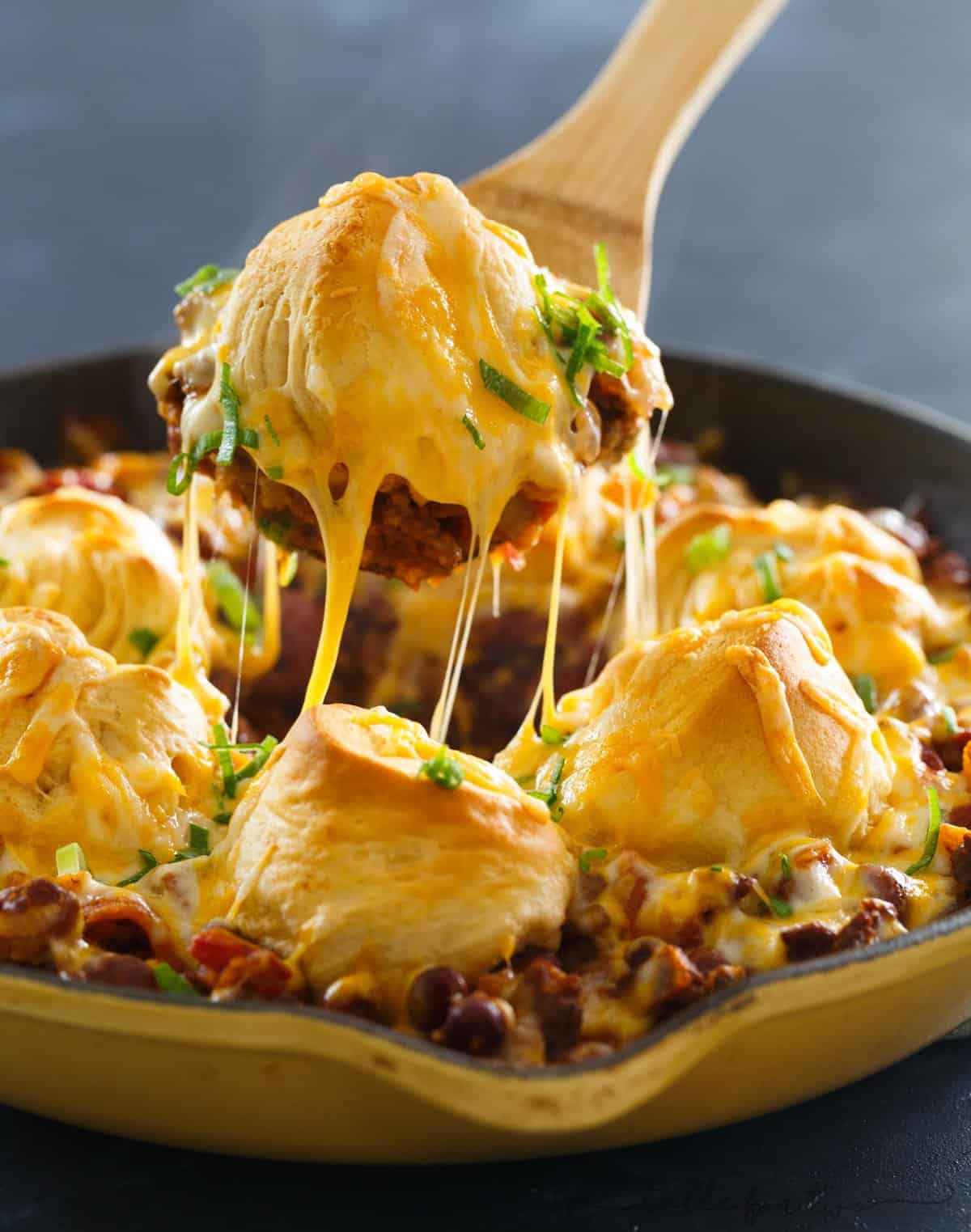 Pure comfort food is right here. Frito pie chili biscuit skillet has your name written all over it if you are looking for something that will stick to your ribs! Chili topped with fritos, cheese, and biscuits — what more could you ask for?!