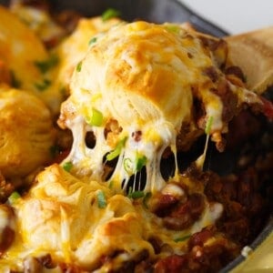 Pure comfort food is right here. Frito pie chili biscuit skillet has your name written all over it if you are looking for something that will stick to your ribs! Chili topped with fritos, cheese, and biscuits — what more could you ask for?!