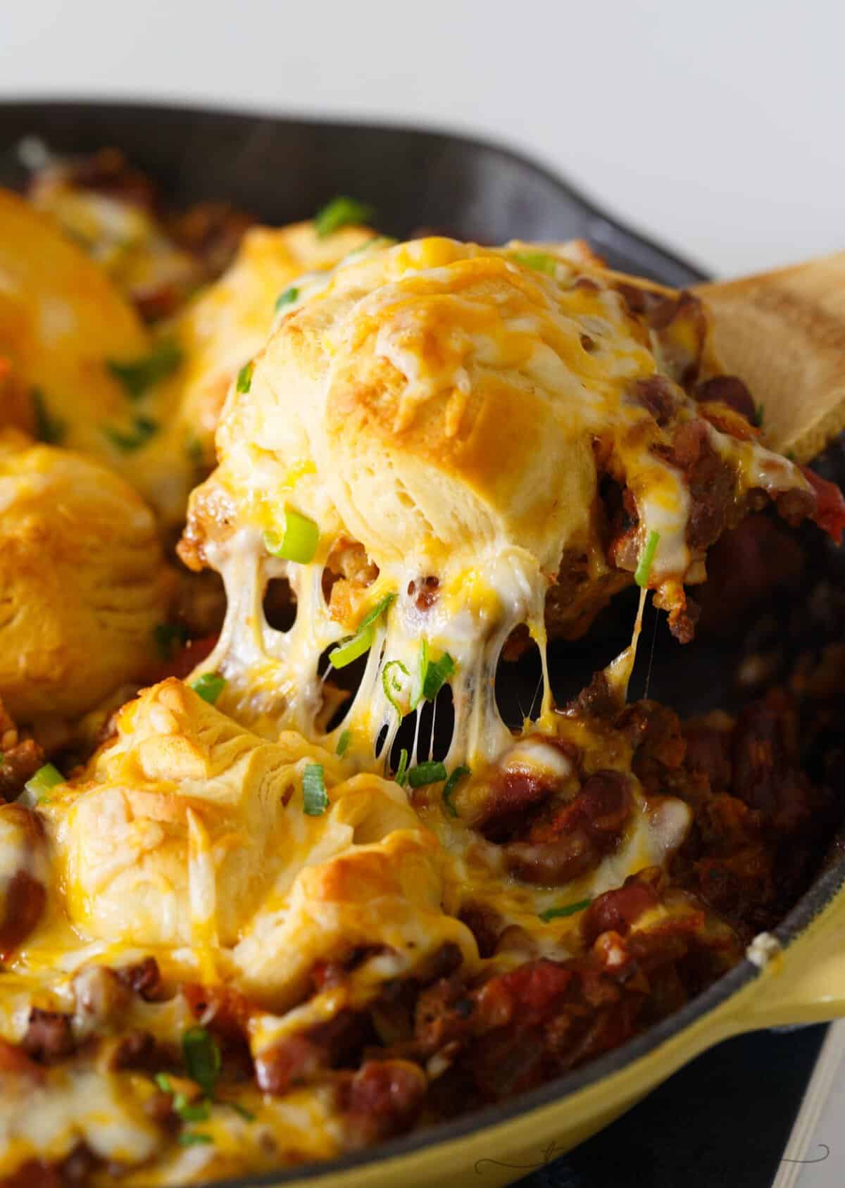 Pure comfort food is right here. Frito pie chili biscuit skillet has your name written all over it if you are looking for something that will stick to your ribs! Chili topped with fritos, cheese, and biscuits — what more could you ask for?!