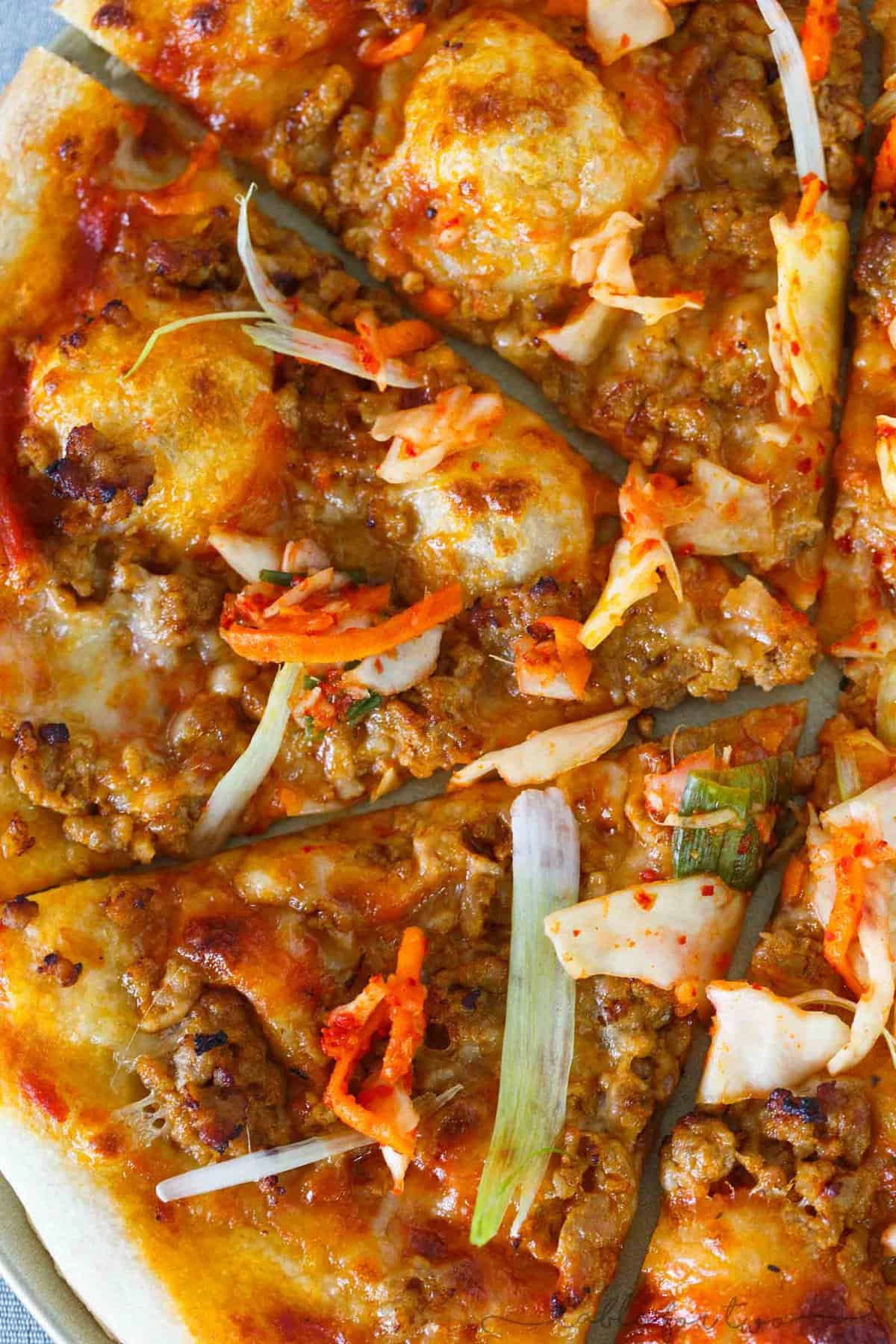 Italy meets Korea in this unique spicy Korean pork pizza recipe! This is a completely fun new way to make and eat pizza if you are a fan of Korean and Asian flavors! The flavors are so bold and perfectly balanced!