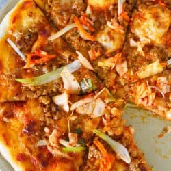 Italy meets Korea in this unique spicy Korean pork pizza recipe! This is a completely fun new way to make and eat pizza if you are a fan of Korean and Asian flavors! The flavors are so bold and perfectly balanced!