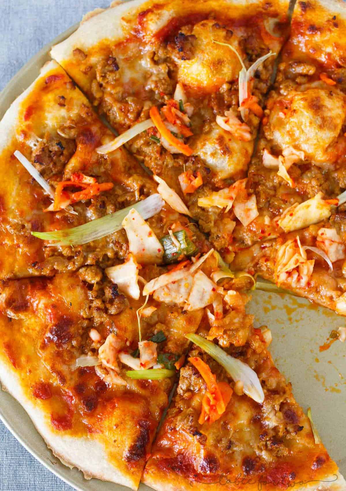 Italy meets Korea in this unique spicy Korean pork pizza recipe! This is a completely fun new way to make and eat pizza if you are a fan of Korean and Asian flavors! The flavors are so bold and perfectly balanced!