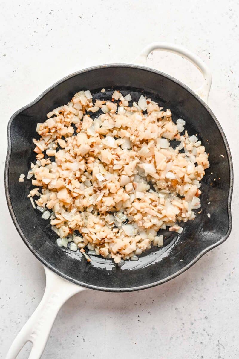 Diced shiitake mushrooms, water chestnuts, and onions in a skillet.