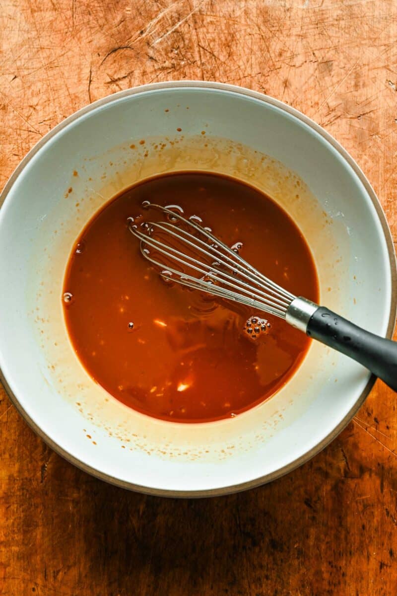 Homemade teriyaki sauce in a bowl with a whisk.