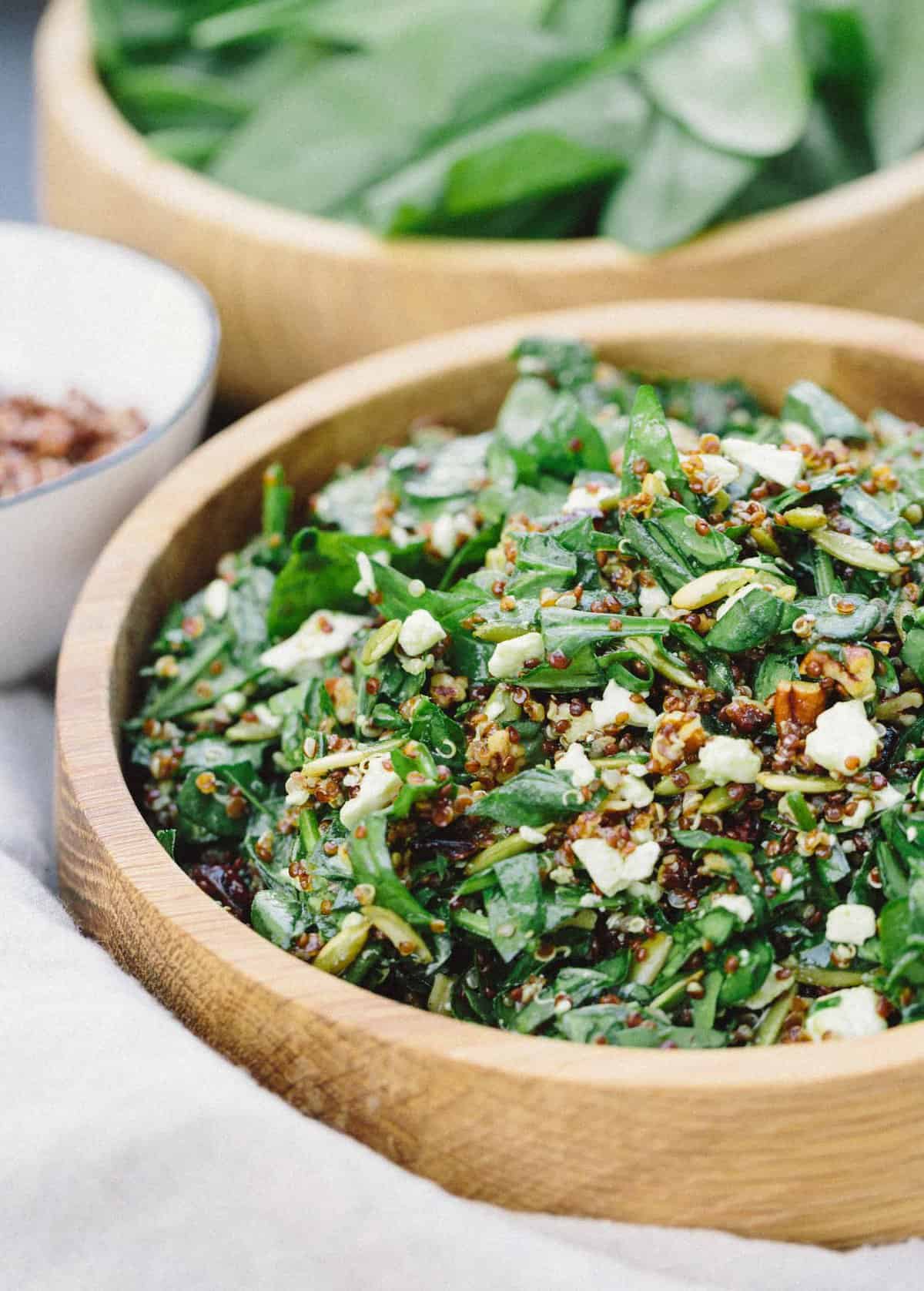 An easy yet elegant nutty spinach and quinoa salad that is perfect as any side accompaniment to any meal! #sidesalad #quinoa #spinachsalad #easysalad #saladrecipe #babyspinach #pumpkinseeds