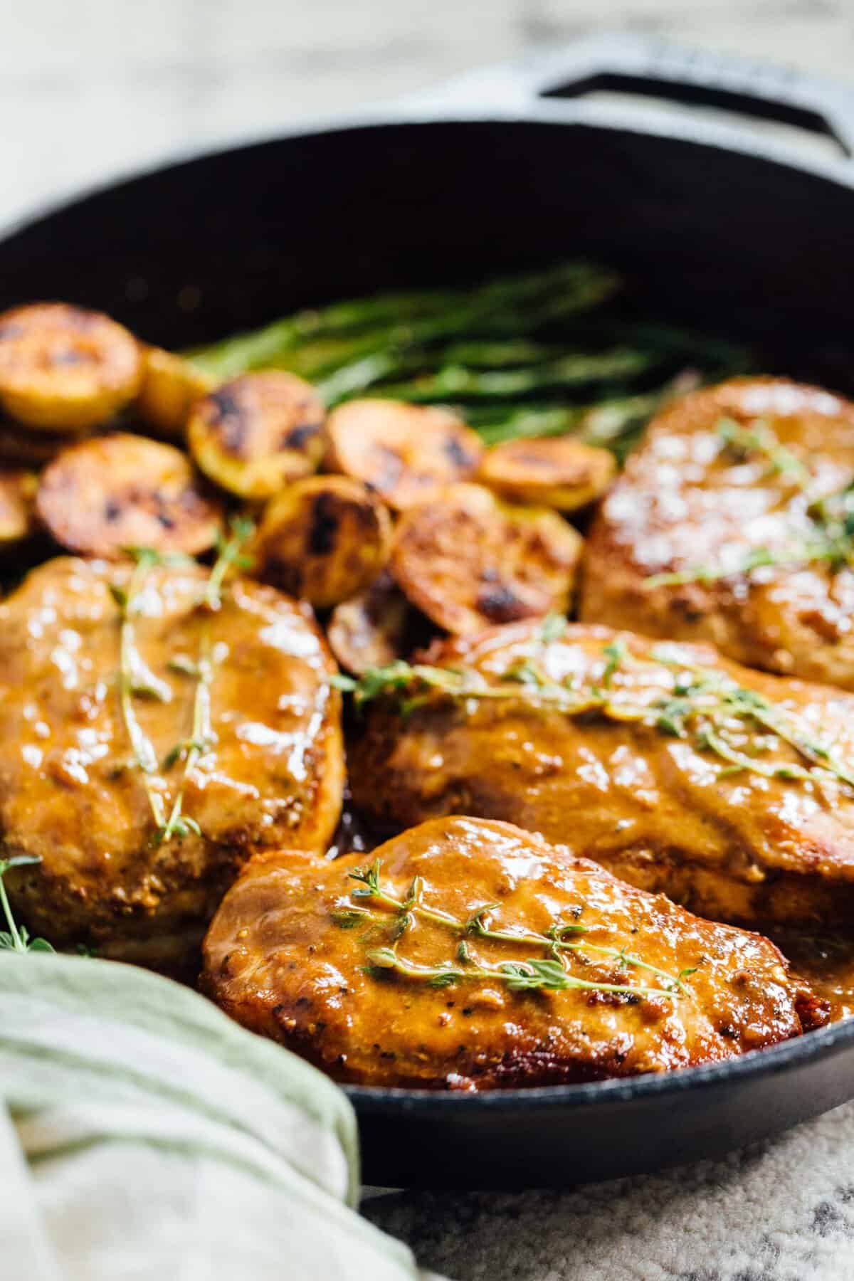 Apricot balsamic pork chops are going to be in your weeknight dinner rotation after your first bite of this sweet and tangy dish! #apricotbalsamic #apricot #porkchops #quickdinner #easydinner #skilletdinner