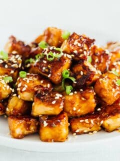 If you aren't totally 100% on board with tofu yet, this pan-fried sesame garlic tofu will have you head over heels in love with it! #tofu #tofurecipe #vegan #veganrecipes
