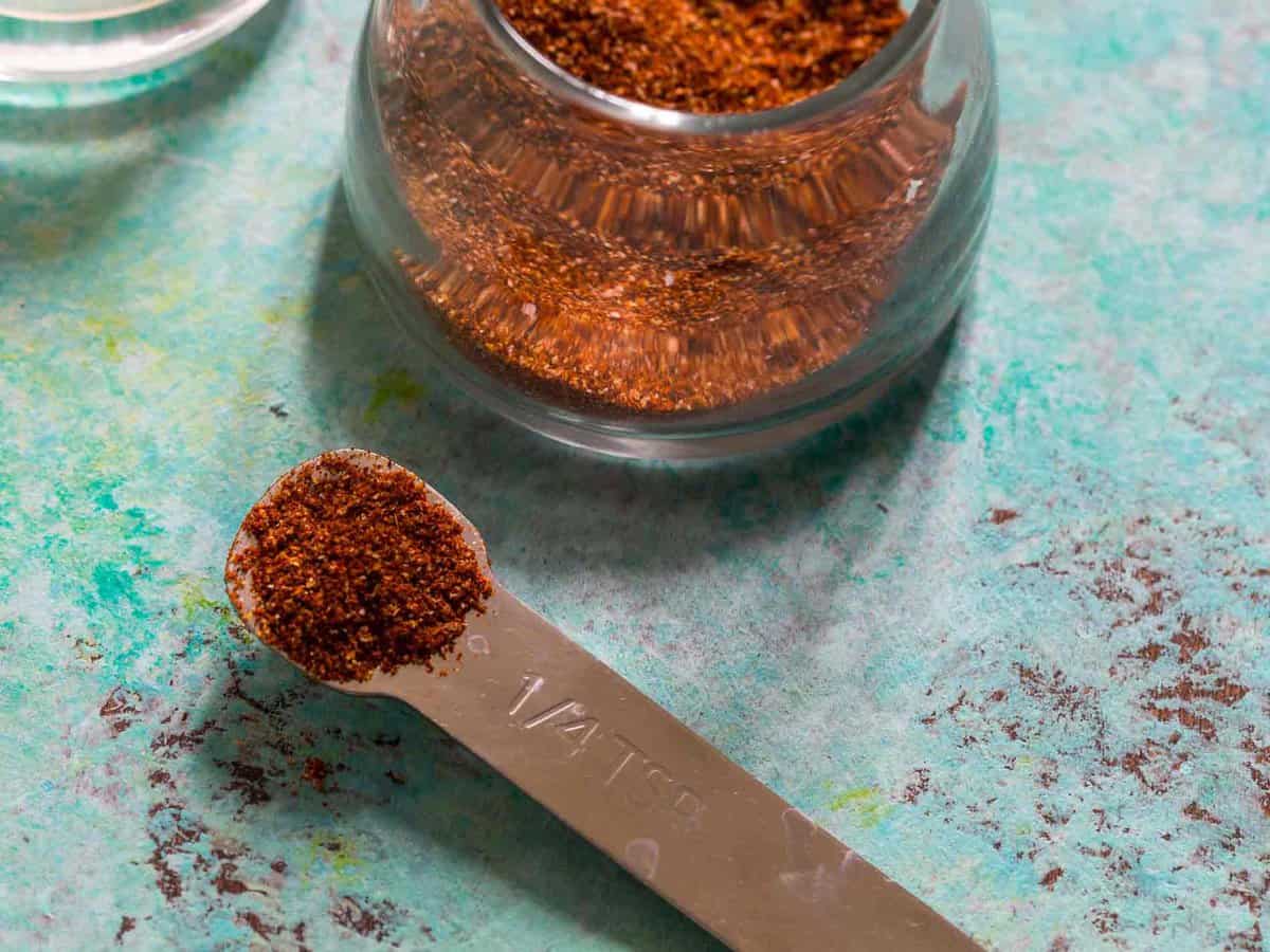 Measuring spoon and glass jar filled with fajita seasoning