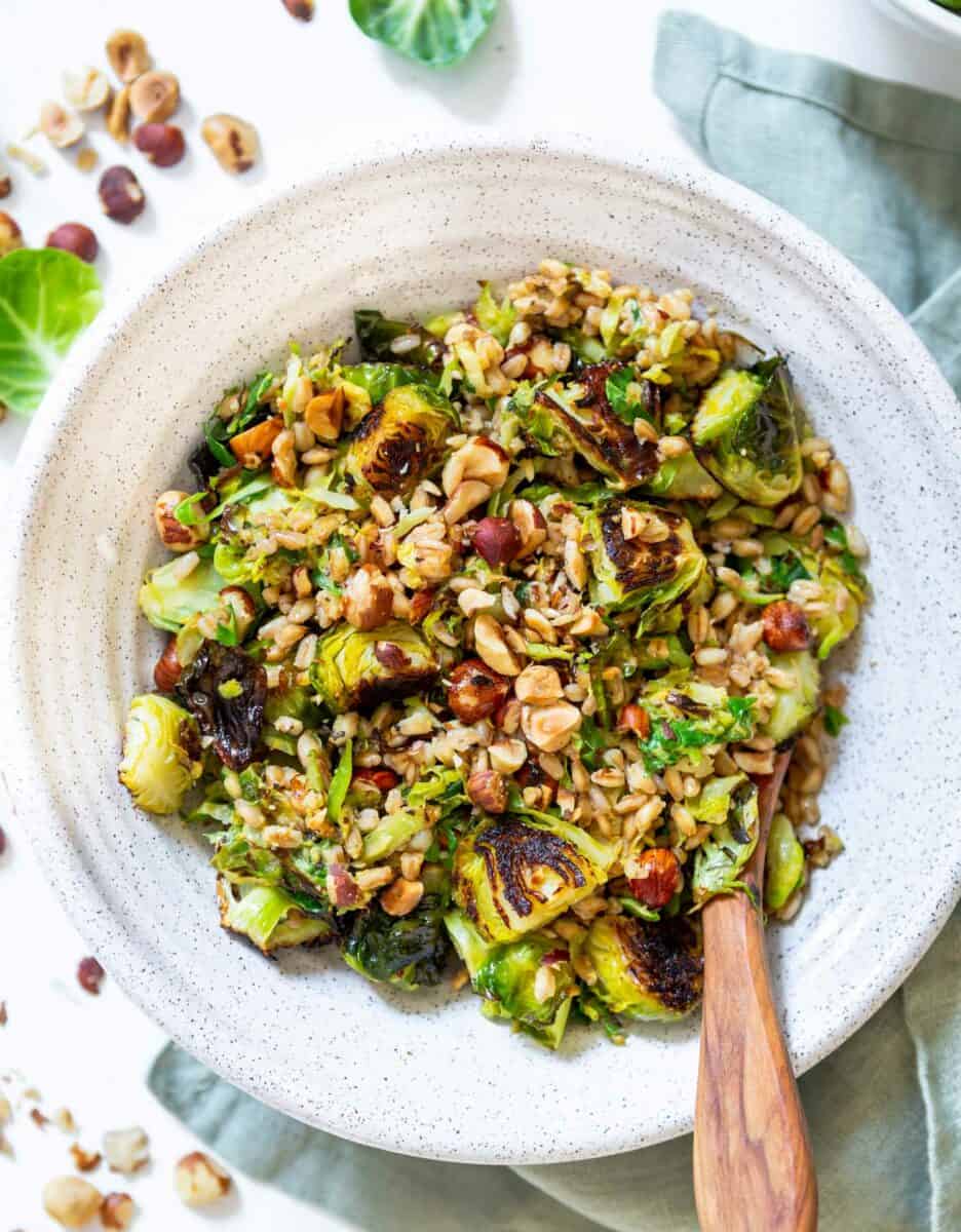 The perfect springtime salad! This warm roasted brussels sprouts salad with farro is tossed in a delicious Dijon shallot dressing that is flavorful and a delight! The hazelnuts give this salad that extra crunch and texture!