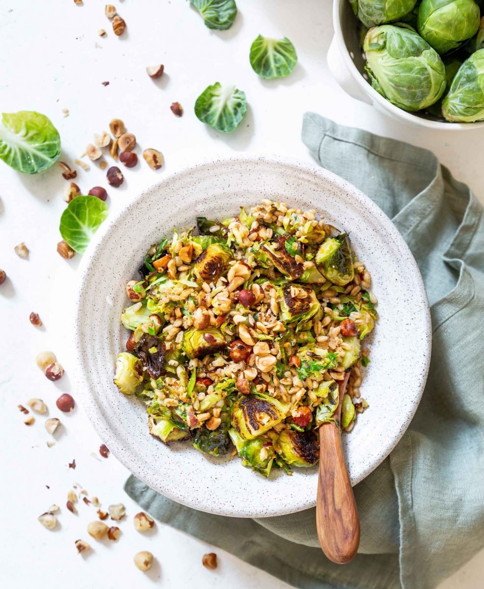 The perfect springtime salad! This warm roasted brussels sprouts salad with farro is tossed in a delicious Dijon shallot dressing that is flavorful and a delight! The hazelnuts give this salad that extra crunch and texture!