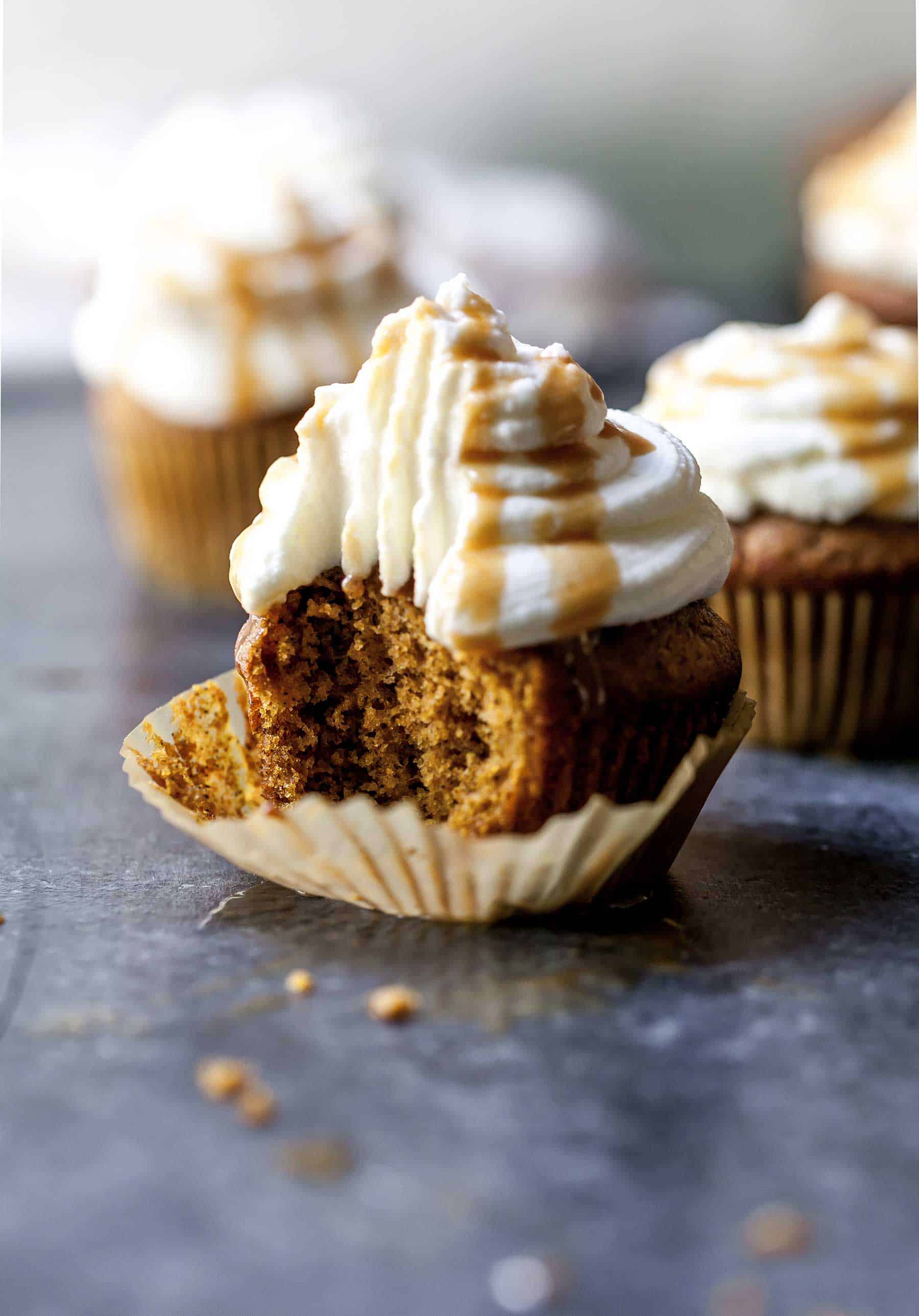 Closeup shot of pumpkin spice latte cupcake unwrapped, with a bite taken out