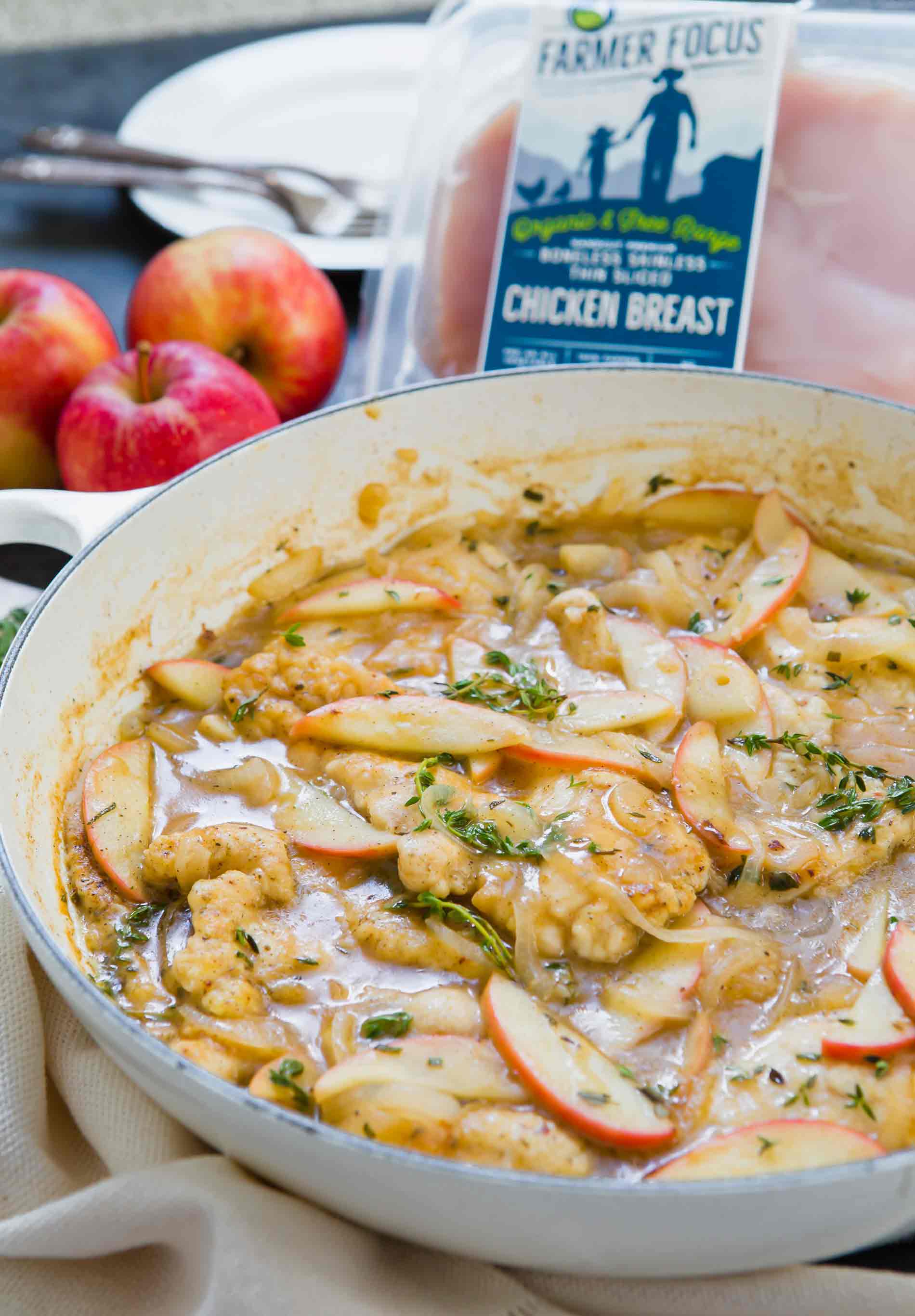 Apple cider chicken skillet with apples and package of chicken in background