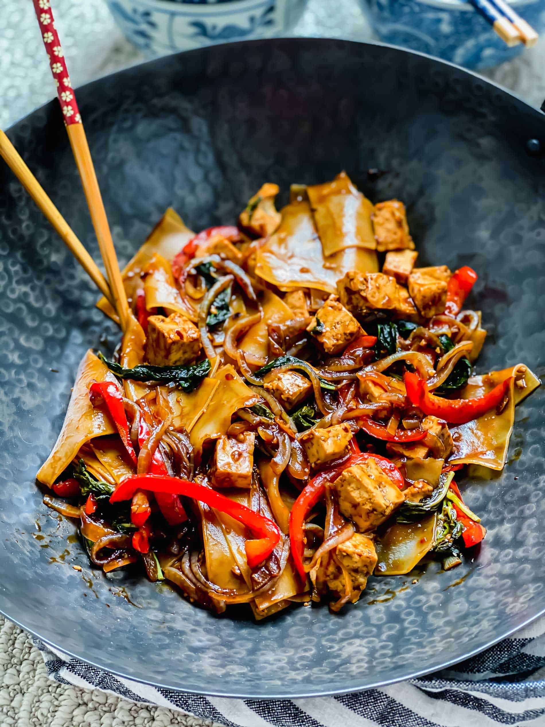 Closeup shot of drunken noodles in wok with chopsticks.