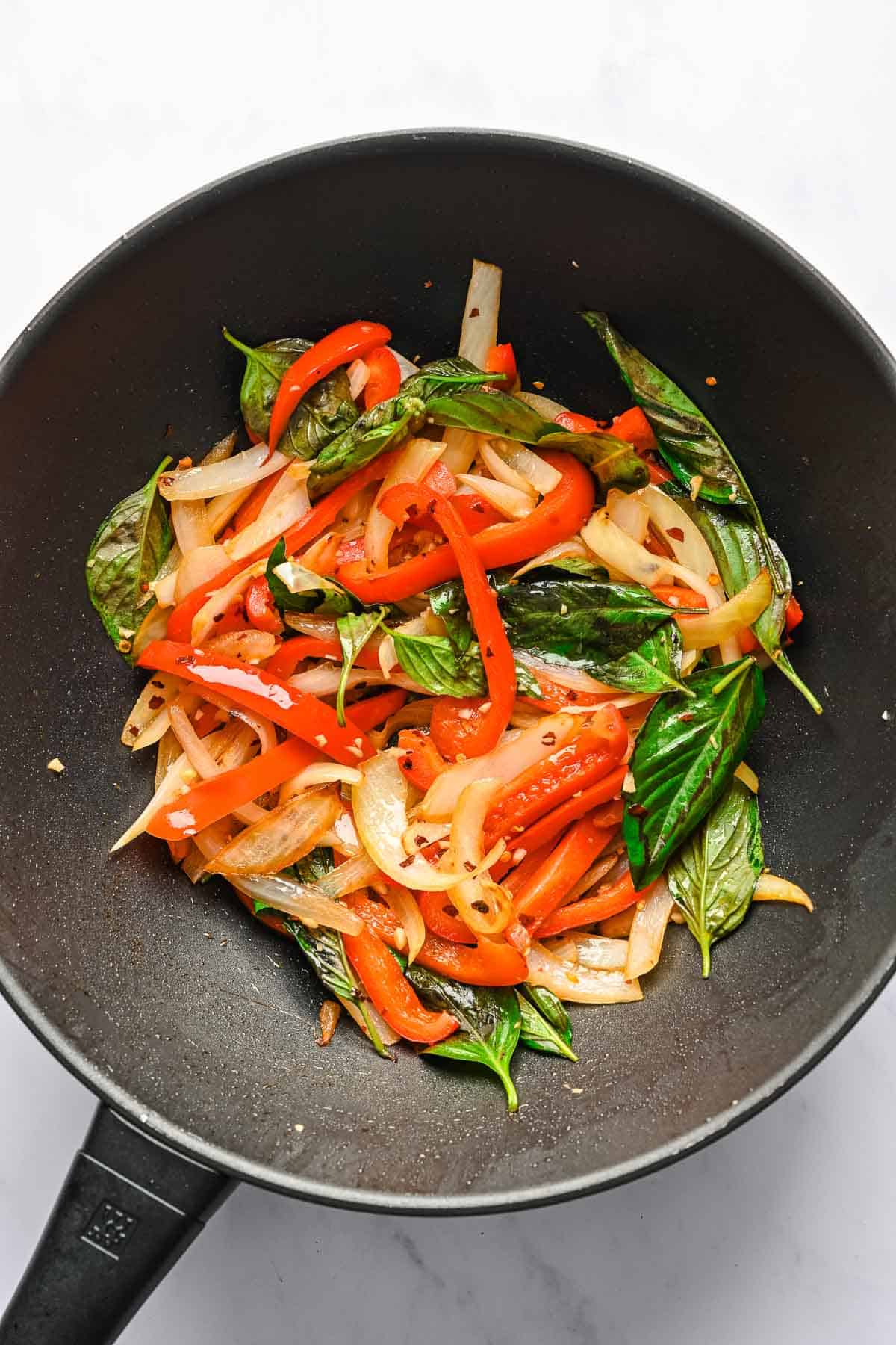 Stir-fried noodles and vegetables in a wok.