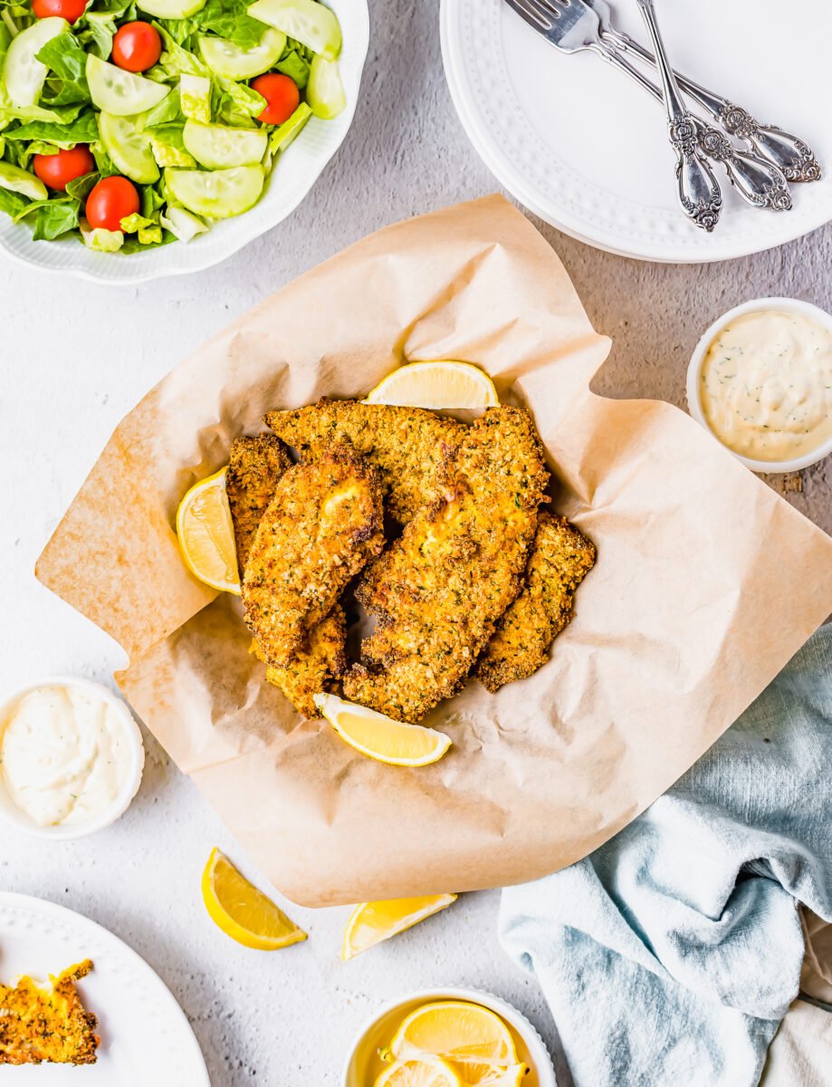 A basket of air fried catfish is lined with brown parchment paper.