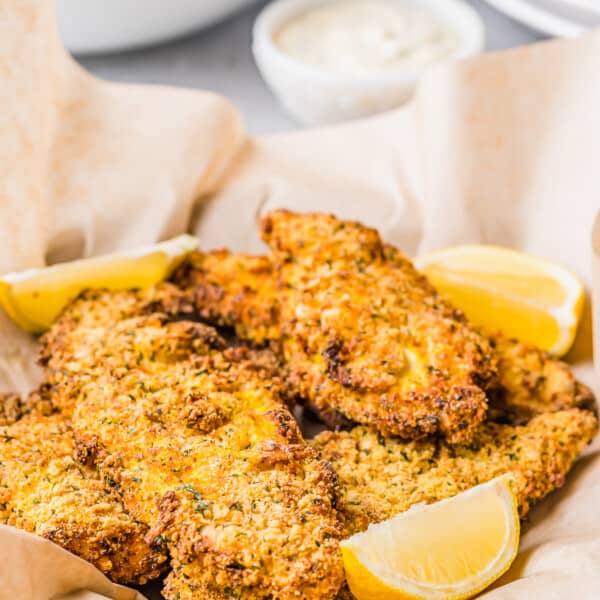 Lemon slices sit in the basket of catfish.