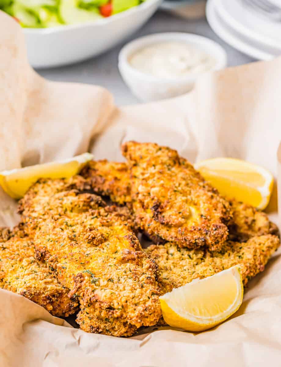 Lemon slices sit in the basket of catfish.