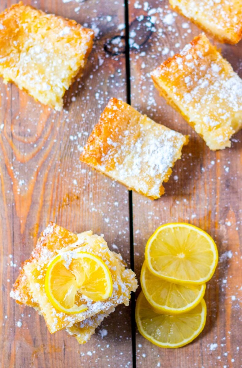 A lemon slice garnishes a square slice of lemon cake. 