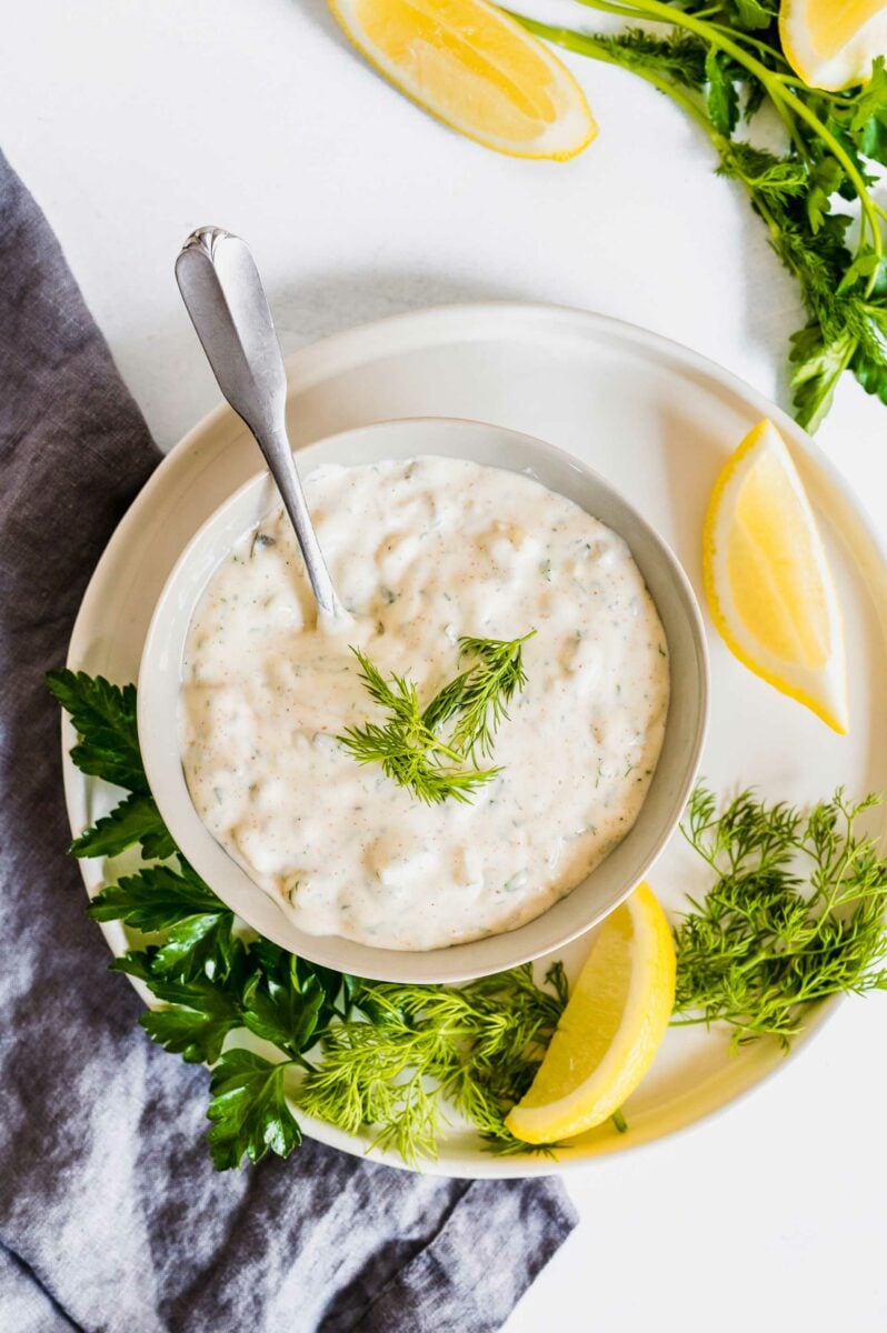 Tartar sauce is presented on a white plate and is ready to be served. 