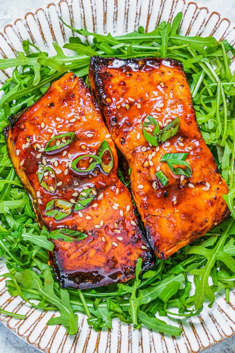 Salmon is topped with sesame seeds and green onions. 