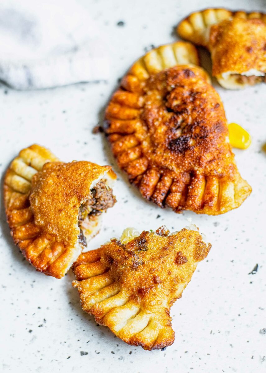 A split empanada is on a white surface. 