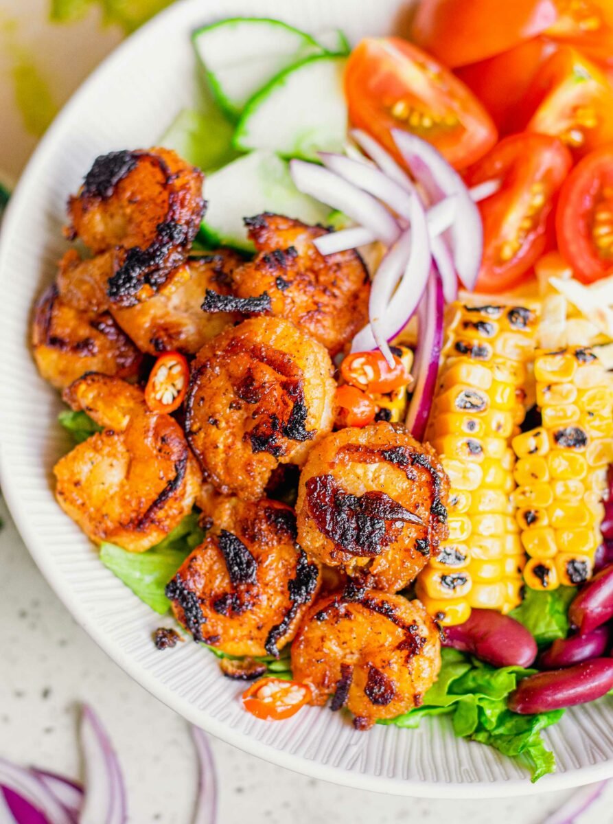 A large portion of blackened shrimp bowl is ready to be eaten. 